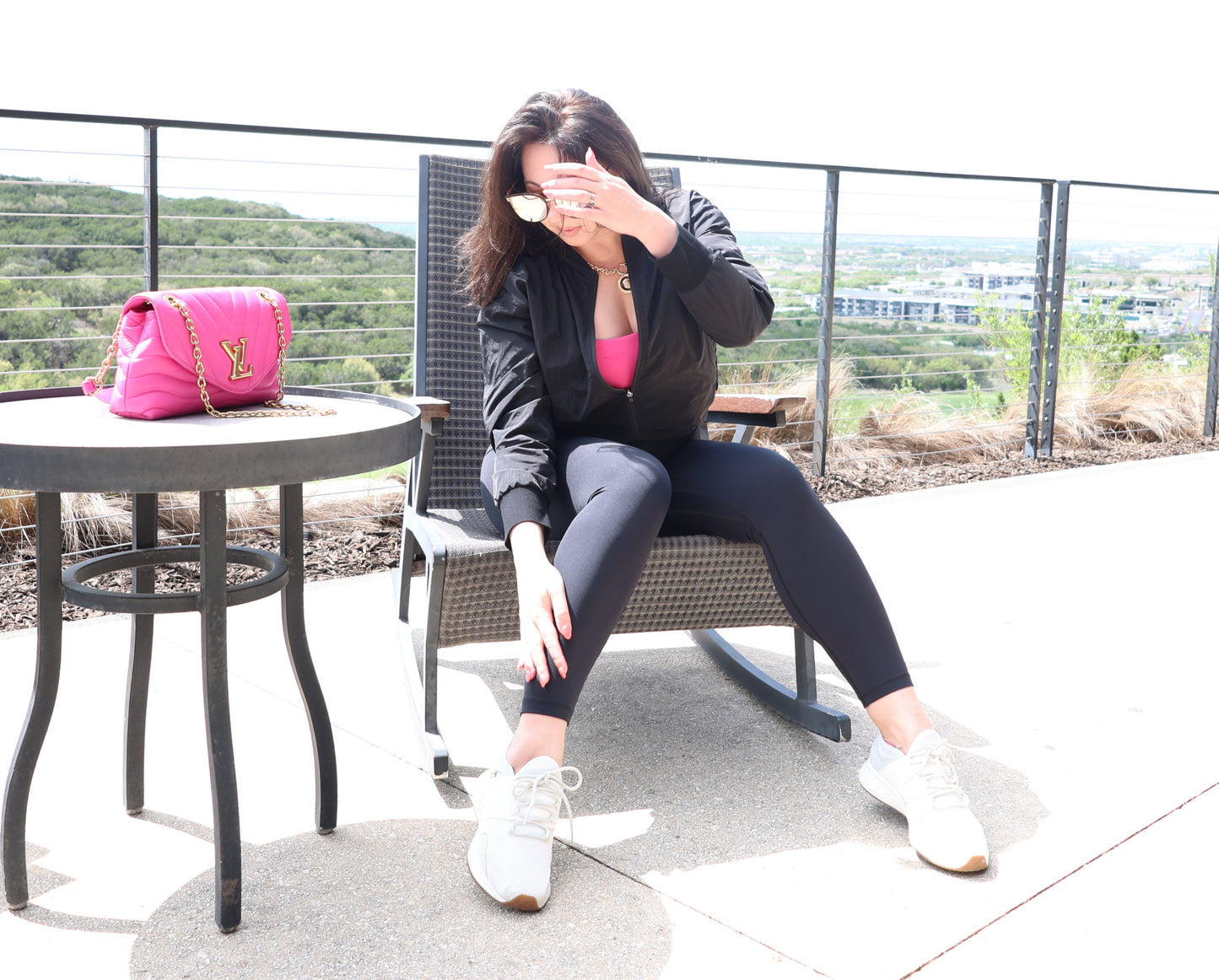 Woman sitting at a table outdoors with a scenic background