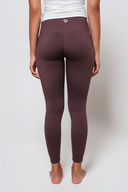 Espresso brown leggings worn by a person on a white background