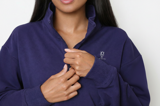 Person wearing a navy blue pullover with a logo on a white background